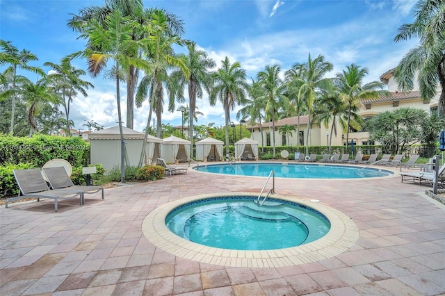 view of swimming pool featuring a patio area and a hot tub