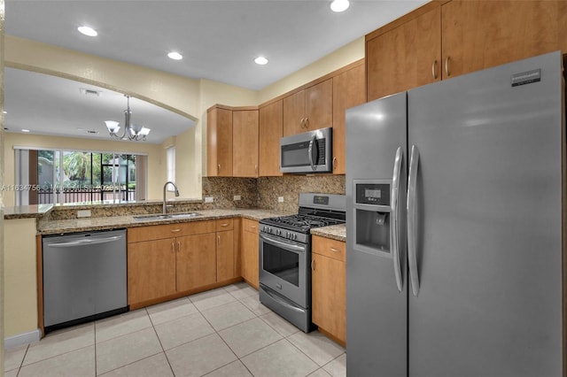 kitchen with pendant lighting, an inviting chandelier, sink, stone countertops, and stainless steel appliances