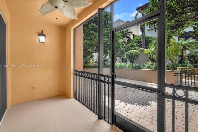 unfurnished sunroom with ceiling fan