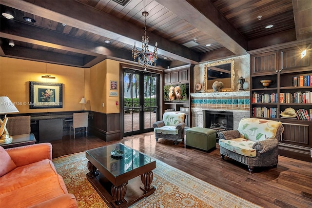 living room featuring dark hardwood / wood-style flooring, french doors, beamed ceiling, and a tile fireplace