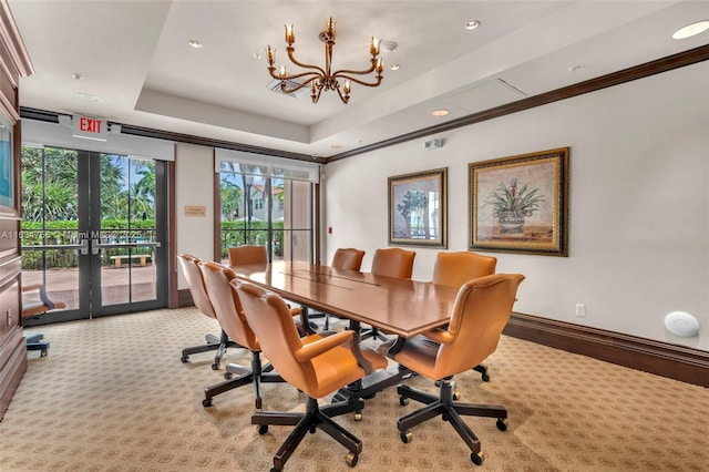 interior space with a chandelier, french doors, a raised ceiling, and crown molding