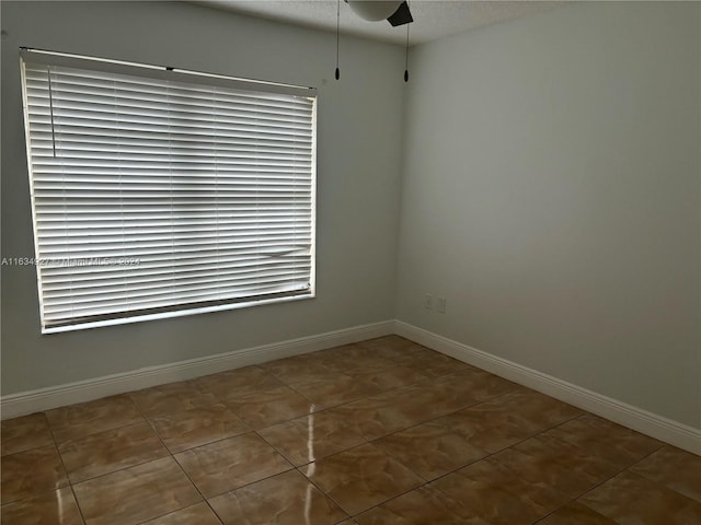 spare room featuring a textured ceiling and dark tile patterned floors