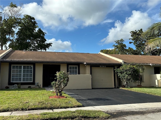 ranch-style home with a garage and a front lawn