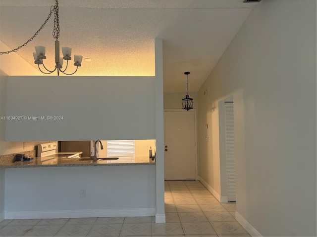 corridor with light tile patterned flooring, a wealth of natural light, lofted ceiling, and sink