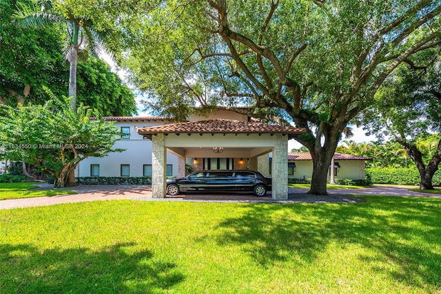mediterranean / spanish home with driveway, a carport, a tiled roof, a front yard, and stucco siding