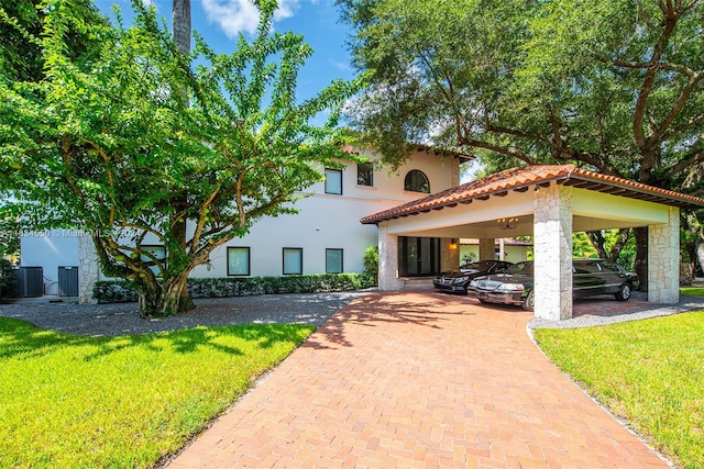 mediterranean / spanish-style home with central AC, a front lawn, and a carport