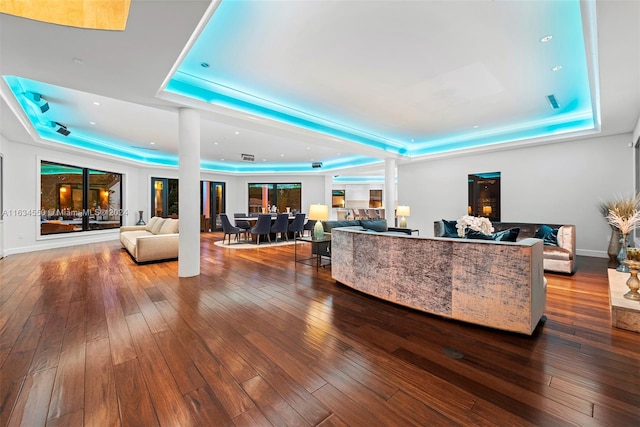 living room with a tray ceiling and hardwood / wood-style floors