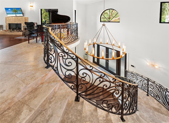 staircase with wood-type flooring and an inviting chandelier