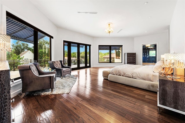 bedroom featuring french doors, a chandelier, access to outside, and hardwood / wood-style floors