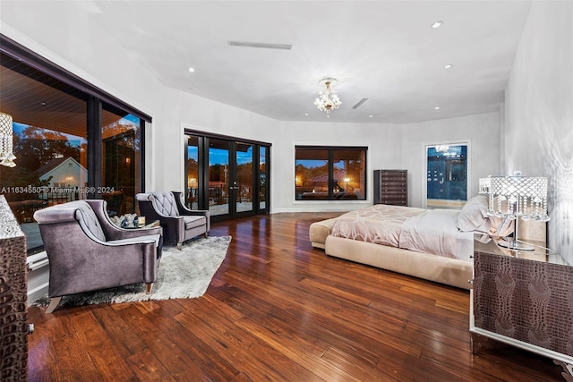 bedroom featuring an inviting chandelier, hardwood / wood-style flooring, access to outside, and recessed lighting