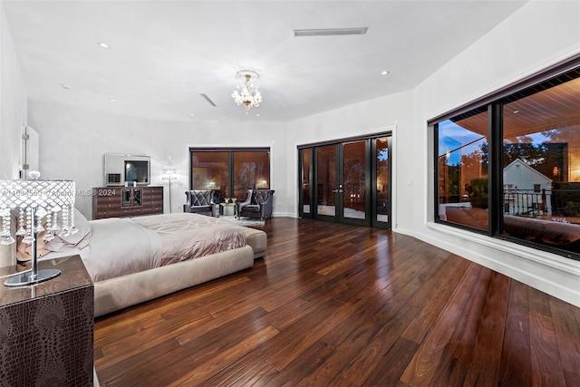 bedroom with an inviting chandelier, wood-type flooring, and access to exterior