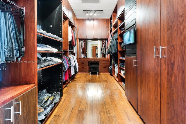 walk in closet with light wood-type flooring