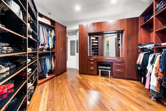 spacious closet featuring electric panel and light hardwood / wood-style flooring