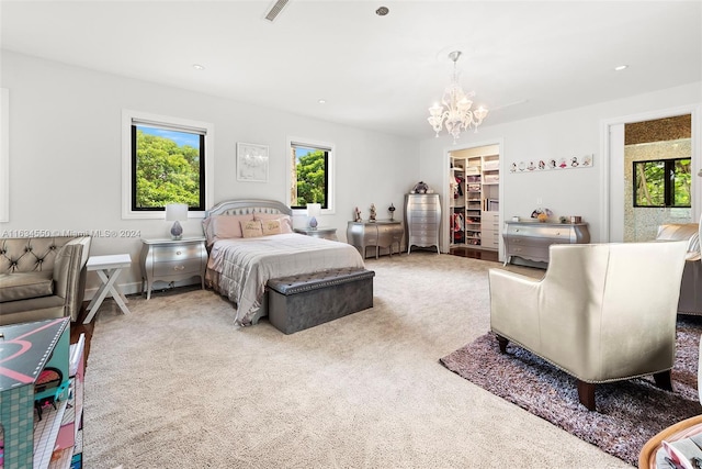 bedroom with a spacious closet, a closet, light colored carpet, and a notable chandelier