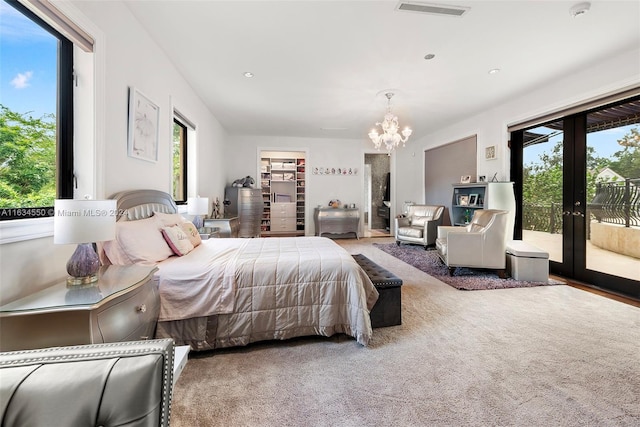 bedroom with multiple windows, an inviting chandelier, french doors, and access to exterior