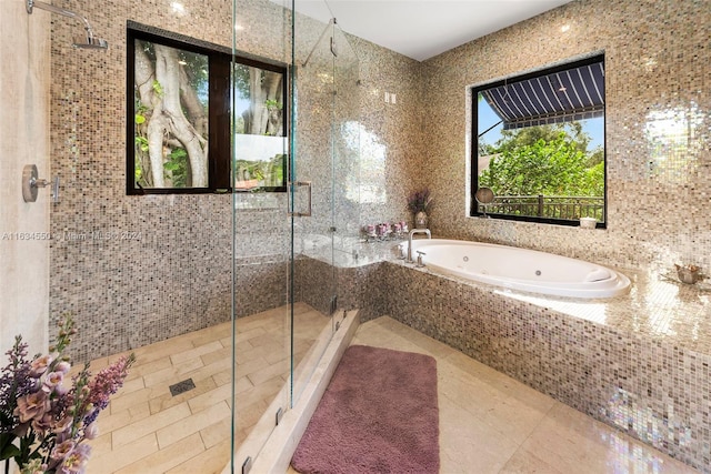 bathroom featuring shower with separate bathtub, tile walls, and tile patterned floors