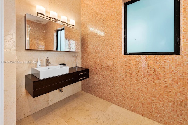 bathroom featuring tile walls and sink