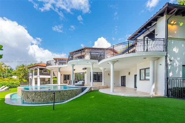 rear view of house featuring a lawn, a balcony, a swimming pool with hot tub, and a patio