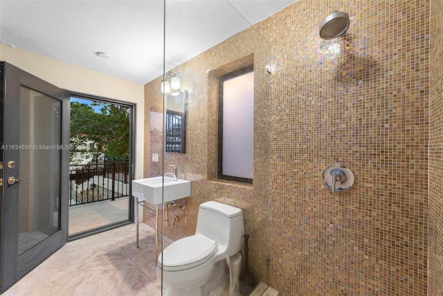 bathroom with tile walls, tile patterned flooring, toilet, and sink