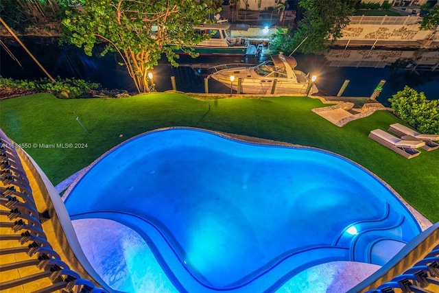 pool at twilight with a lawn and a jacuzzi