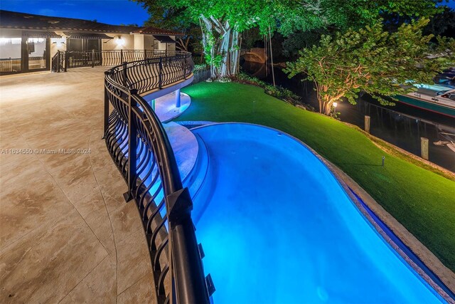 view of swimming pool with fence and a yard