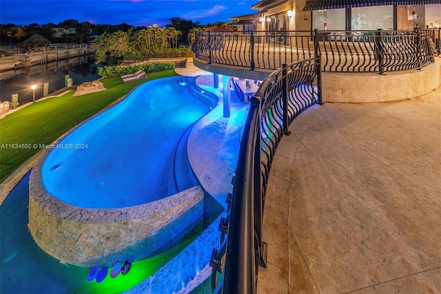 pool with a lawn, a patio, and fence