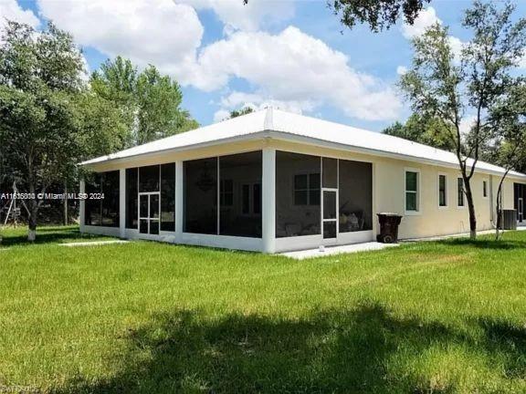 back of house featuring a sunroom and a yard