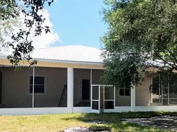 rear view of property featuring a sunroom