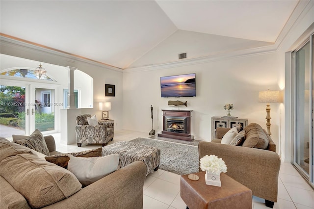 living room featuring light tile patterned floors, visible vents, vaulted ceiling, and a glass covered fireplace