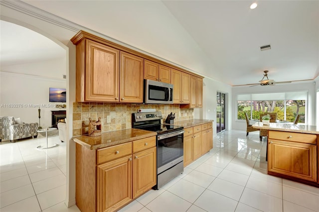 kitchen with appliances with stainless steel finishes, tasteful backsplash, light tile patterned floors, and ceiling fan