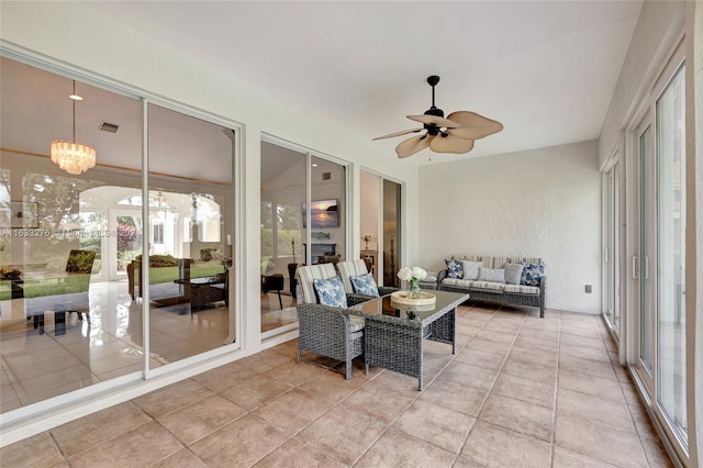 sunroom / solarium featuring ceiling fan with notable chandelier