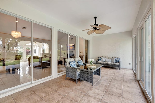 sunroom / solarium with ceiling fan with notable chandelier