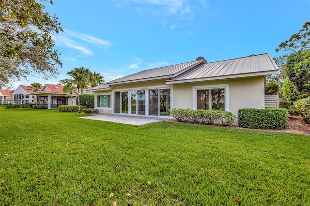 back of property with a patio and a yard