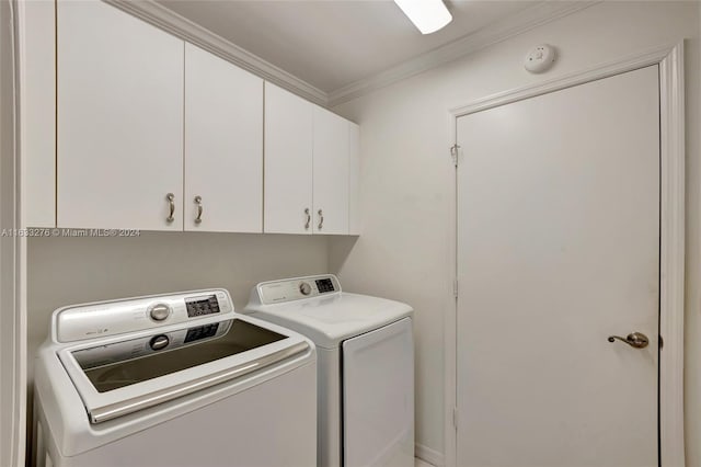 laundry area featuring washer and clothes dryer, cabinets, and ornamental molding