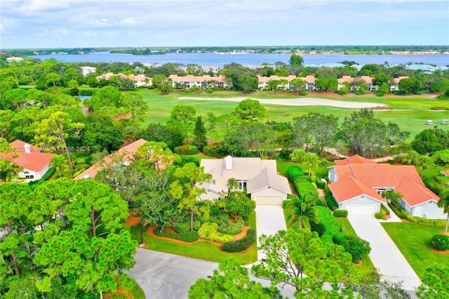 drone / aerial view with a residential view, view of golf course, and a water view