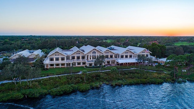 aerial view at dusk featuring a water view