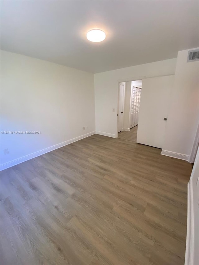 empty room with hardwood / wood-style flooring