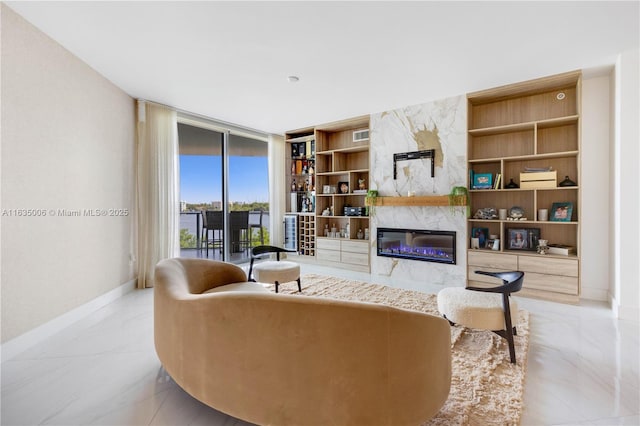 living room featuring built in shelves, a high end fireplace, and floor to ceiling windows