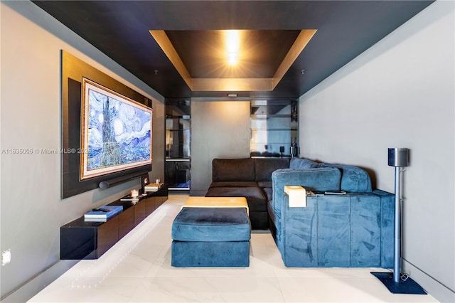 tiled home theater room featuring a tray ceiling