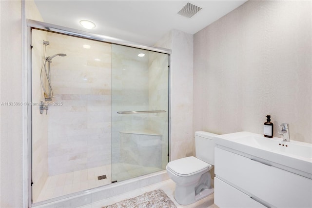 bathroom featuring tile patterned floors, a shower with door, vanity, and toilet