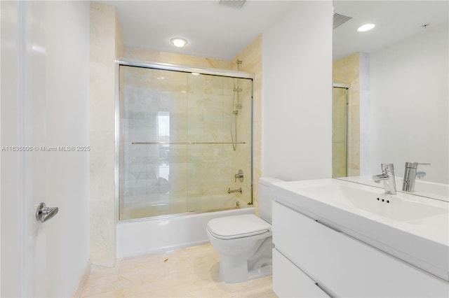 full bathroom with tile patterned floors, toilet, vanity, and combined bath / shower with glass door