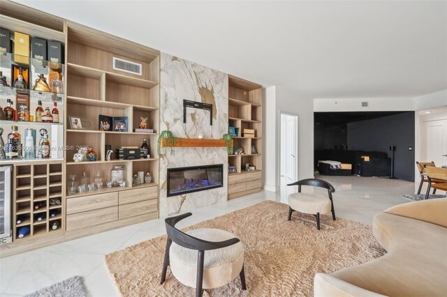 living room featuring wine cooler, built in features, and a premium fireplace