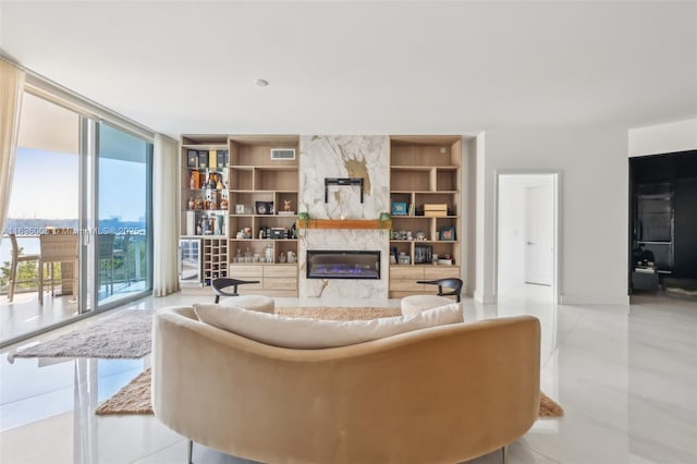 living room featuring built in shelves, expansive windows, light tile patterned floors, and a fireplace