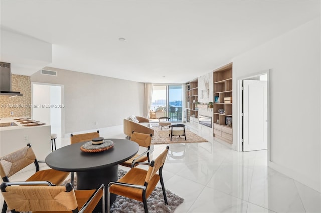 tiled dining room with floor to ceiling windows and built in features