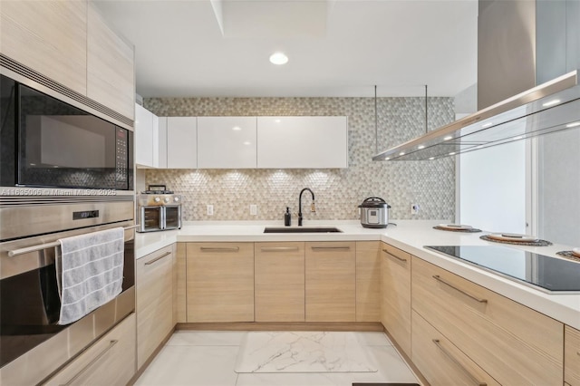 kitchen featuring light brown cabinetry, sink, range hood, and black appliances