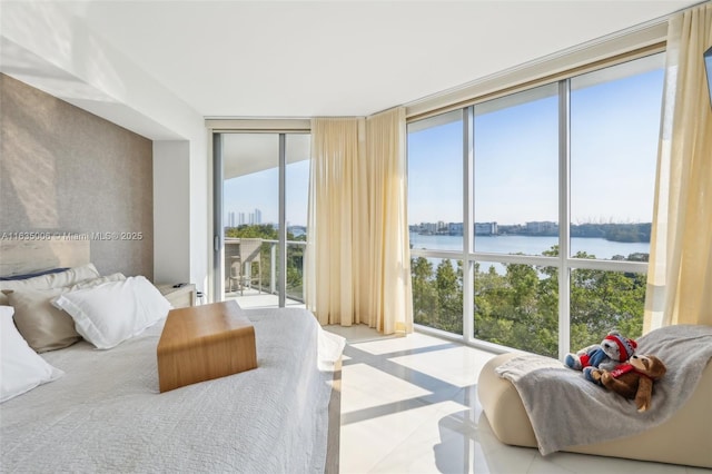 bedroom with a water view, a wall of windows, and access to outside