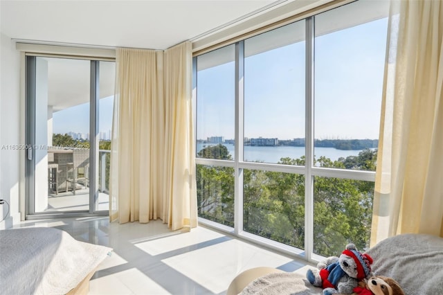 bedroom with a water view and a wall of windows