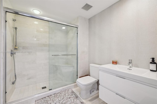 bathroom featuring tile patterned flooring, a shower with door, vanity, and toilet