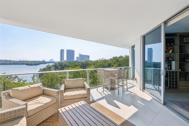 balcony with outdoor lounge area and a water view