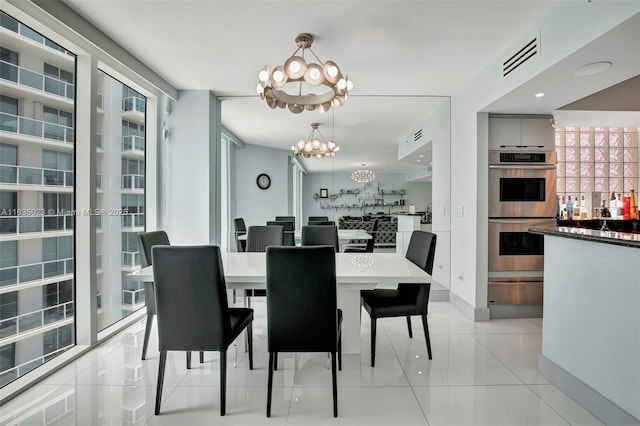 dining room with baseboards, a notable chandelier, visible vents, and light tile patterned floors